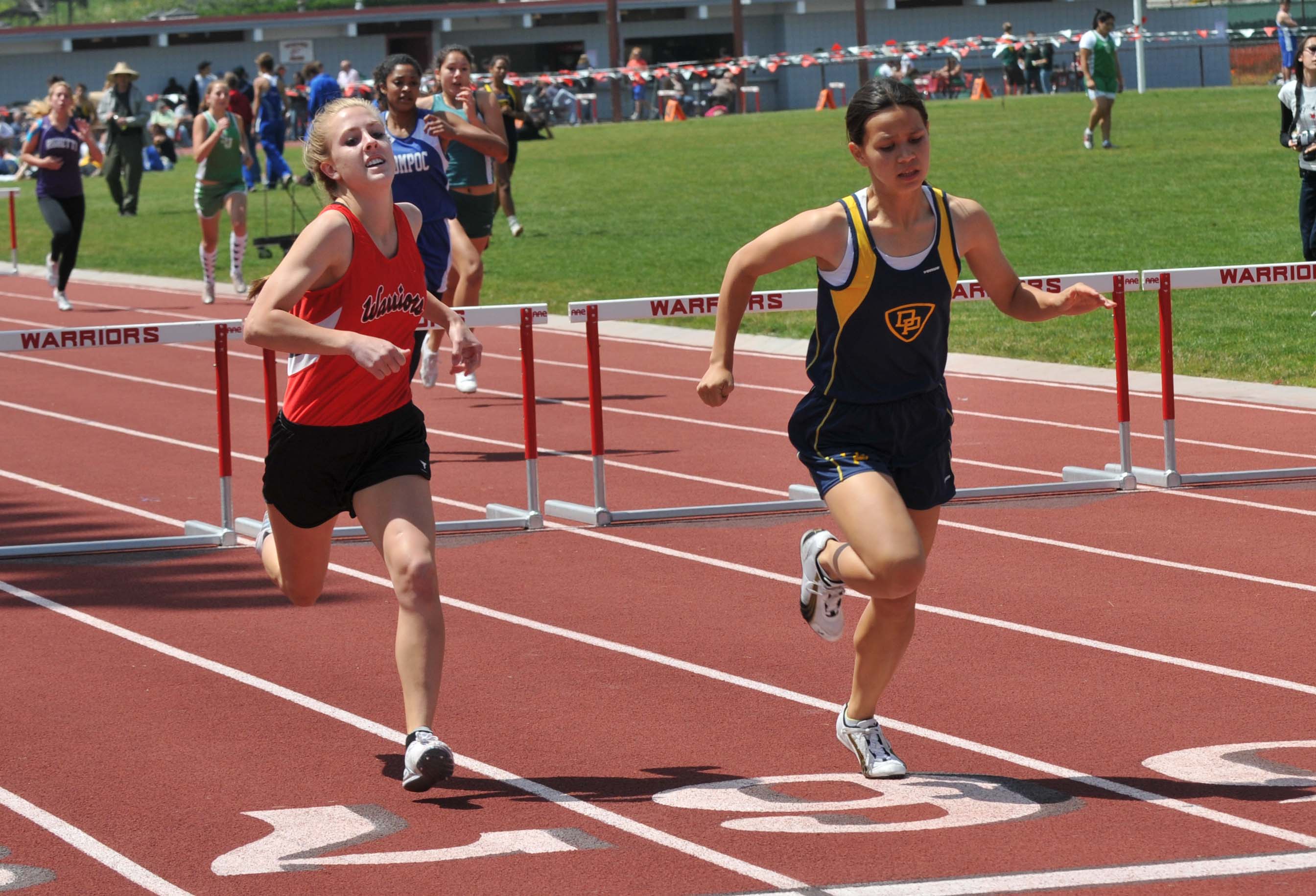Dos Pueblos' Michelle Gee, right, edges Carpinteria's Shelby Dunlap for second place in the girls 300 hurdles.