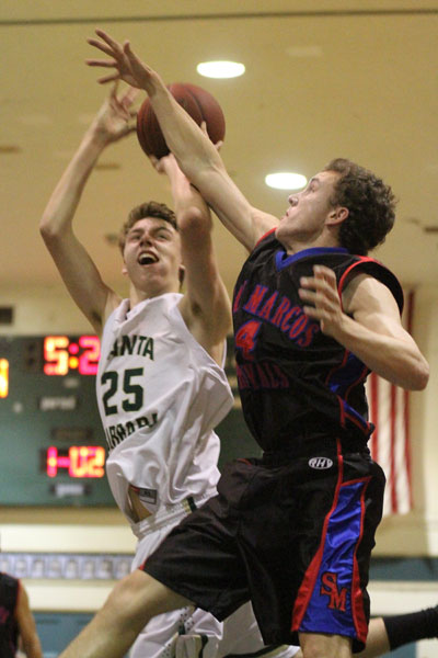 Dons forward Jack Baker fights through the tough defense of Paxton Ridgeway for a bucket in the first quarter.