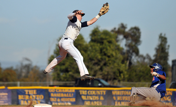 Dos Pueblos shortstop Ben York leaps to catch a throw from catch Luke Coffey. San Marcos baserunner Isaac Rodriguez was safe under the tag. (Presidio Sports Photo)