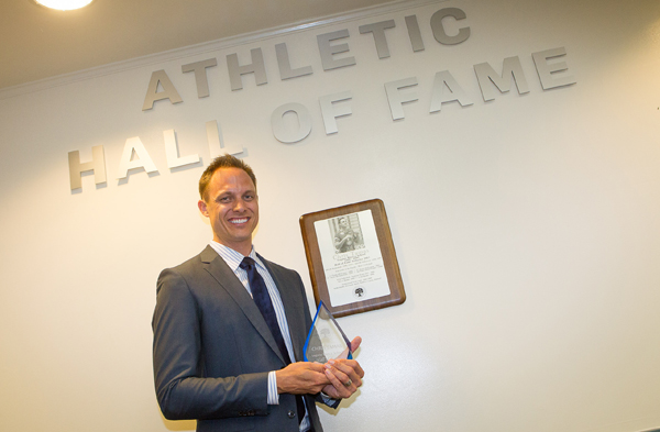 Chris Tamas with his award in front of the new Athletic Hall of Fame
