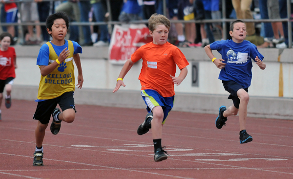 Fifth and sixth grade boys race towards the finish line in the 100-meter sprint.