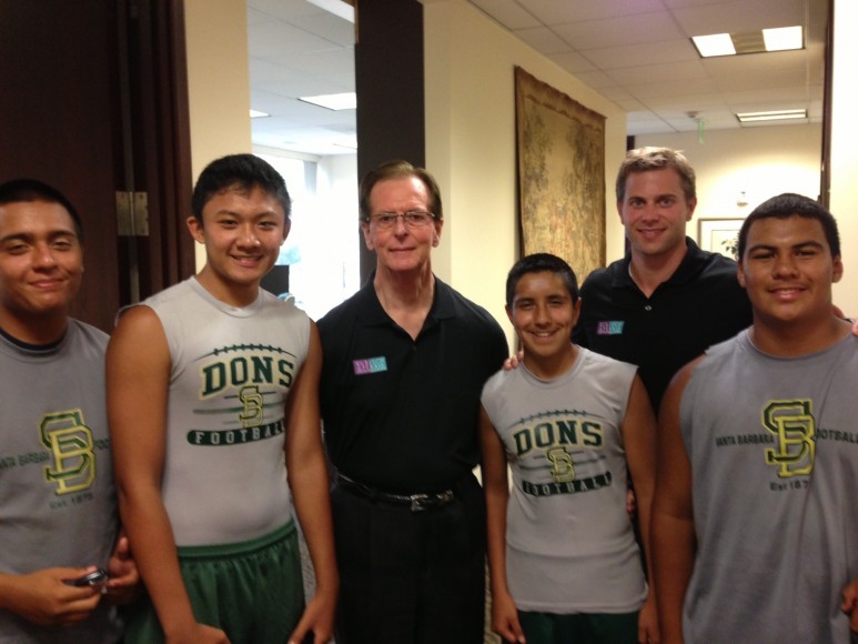 Santa Barbara High football players pose with local orthodontist Drs. Raymond Kubisch, left, and Andrew Ferris.