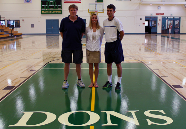 Jeff King, Kira Fay, and Greg Tebbe stand on the newly renovated floor in JR Richards Gymnasium at Santa Barbara High School. 