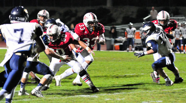 Peter Ramos of Carpinteria runs through a hole opened up by the offensive line.