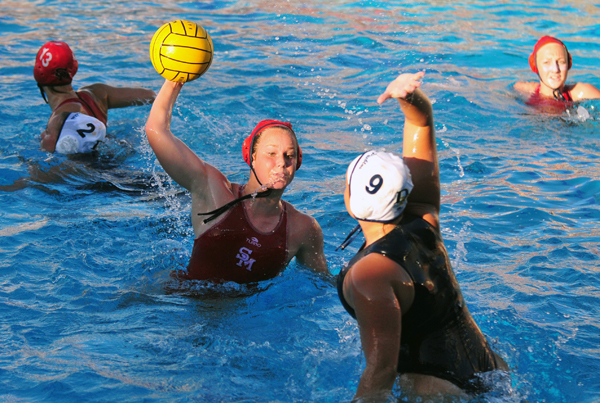 Dos Pueblos' Jordan Williams gets high out of the water while defending a shot by San Marcos' Frannie Kuesis.