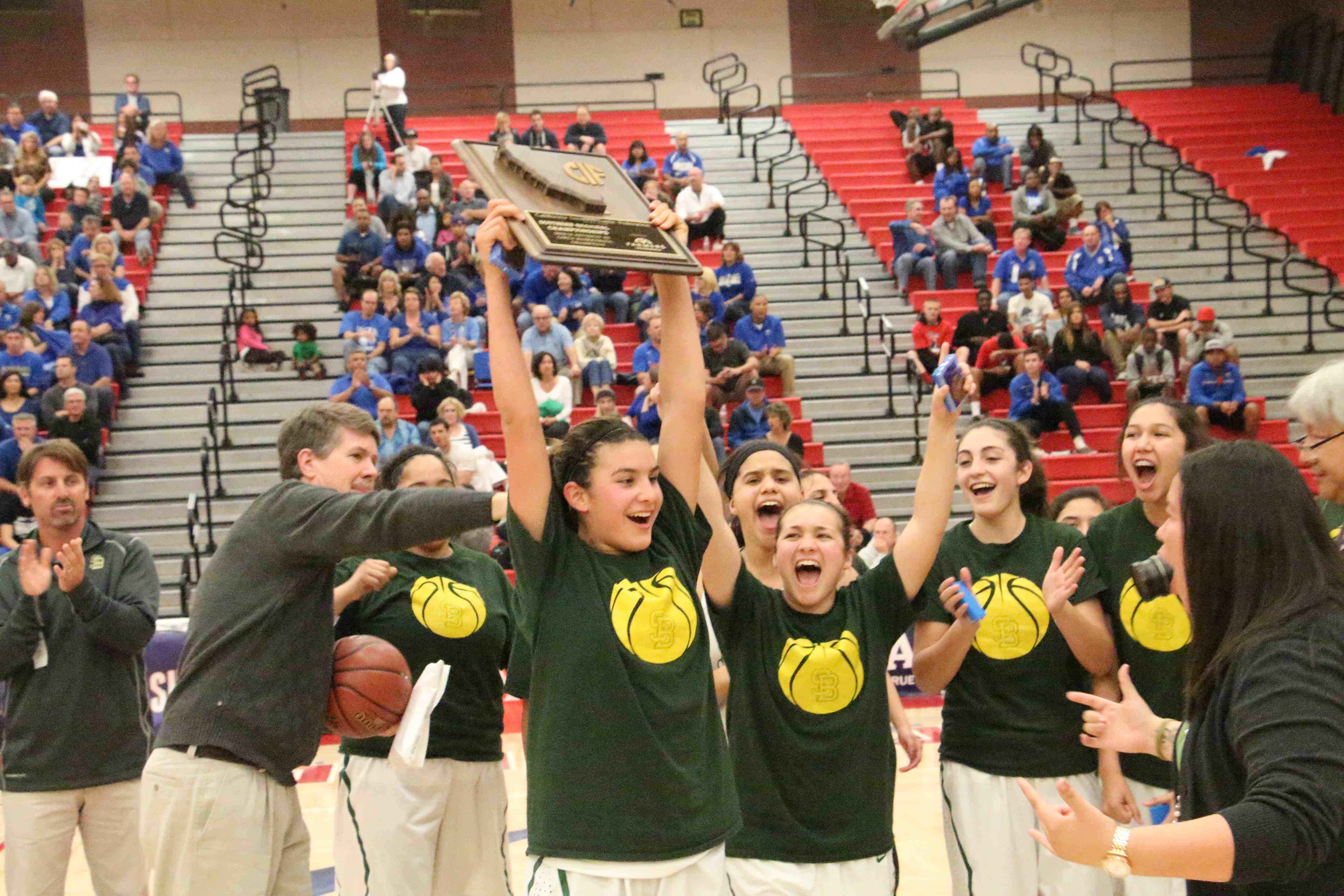 Amber Melgoza holds up the CIF Regional title plaque as her  Santa Barbara teammates celebrate after beating Santa Margarita, 58-48, in the Division 3 regional final.