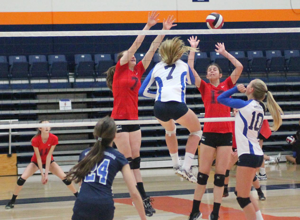 Danica Minnich hits through the block as 14-Blue teammate Ady Collet looks on