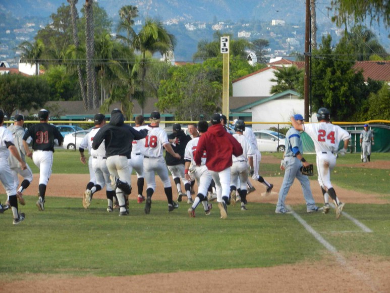 SBCC players rush the field to celebrate after James Hill hit a sacrifice fly to score Connor McManigal with the game-winning run in the 10th inning.
