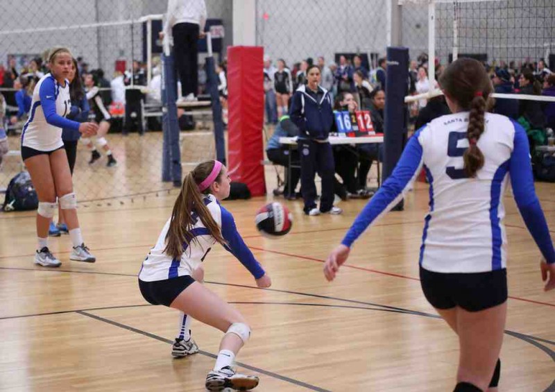Emily Robertson of the SBVC 16-Blue passes as Lourda Weger (5) looks on and Chloe Allen (13) gets ready to hit.