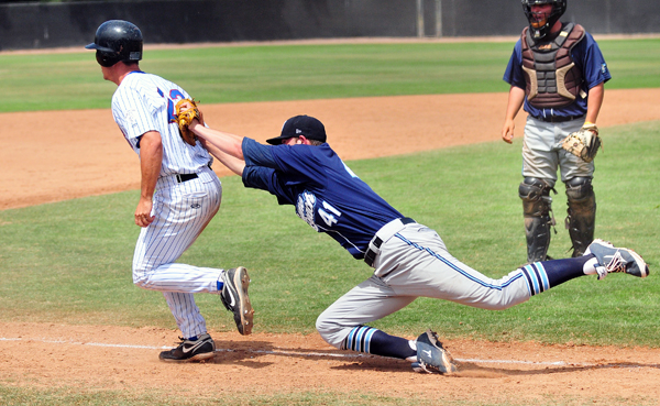 Neptune Beach pitcher Ian Clark dives to tag out Santa Barbara's David Greer in a rundown between home and third base. 
