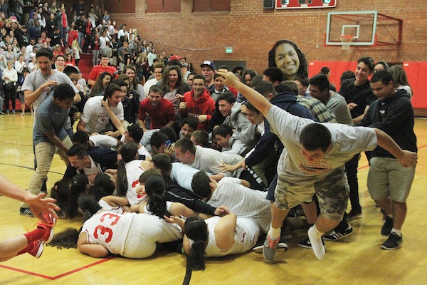 Members of the Bishop Diego football team storm the court and bowl over girls basketball team after its state tournament victory over Bakersfield Christian on Wednesday night (Photos by Thomas Salgado Jr.)