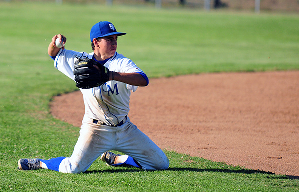 San Marcos' Kyle Gonzalez throws from his knees for an out at third base after a diving stop.