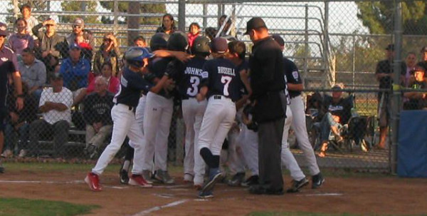 Aiden Johson is mobbed at home plate after his second-inning grand slam in the championship game against Santa Paula.