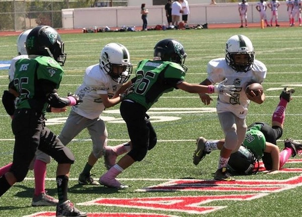 Michael Monty Lopez of the Santa Barbara Sharks Pee Wee team breaks free from a Thousand Oaks tackler during a 44-12 win.