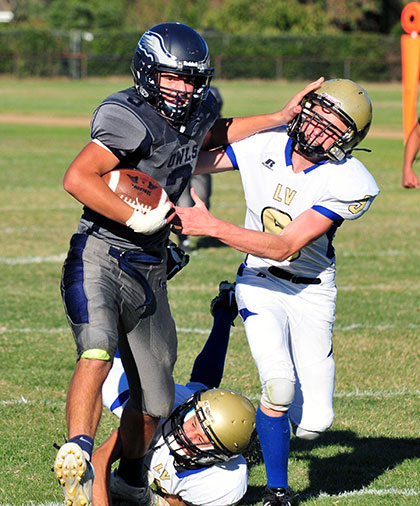 Laguna Blanca sophomore Anton Homeniuk finishes off a big gain carrying two tacklers.