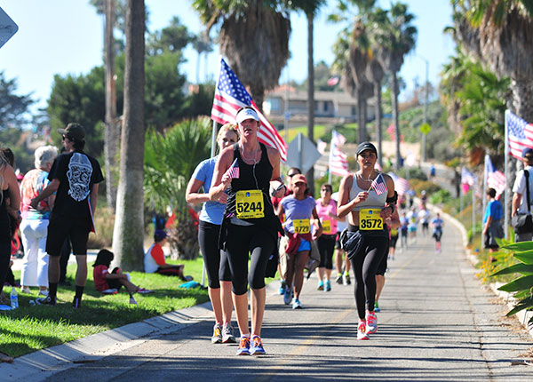 Runners approach the finish area of the Santa Barbara Half Marathon. The final mile is lined with American flags in honor of Veterans Day. (Presidio Sports File Photo)
